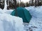 Collected green tent in the forest in winter. Overnight in a tent in extreme conditions. Tourism for people of strong