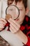 Collecting coins. The boy examines an old coin through a magnifying glass. Dollars, euros on the table. Money of different nations