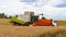 Collecting wheat combine, unloading seeds in truck