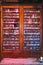 Collection of bottles of beer inside a warm and antique double glass door shelf