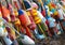 A collection of buoys leaning against a fence