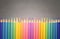 collection of color pencild laying in row striaght line made by pencil tips with grey background close up, Color pancils, copy