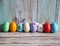 A collection of colorful eggs and funny handmade textile Easter bunnies on a light blue wooden background.