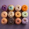 a collection of colorful frosted donuts on a purple background