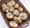 A collection of cremini mushrooms in a basket placed on a white background.