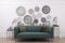 Collection of different clocks and comfortable sofa in stylish room. Interior design