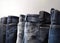 Collection of different color models of denim pants in a row, white background. AI generated.