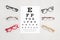 Collection of eyeglasses with eye test table. Optical store, glasses selection, eye test, vision examination at optician, fashion