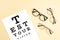 Collection of eyeglasses with eye test table. Optical store, glasses selection, eye test, vision examination at optician, fashion