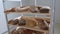 Collection of fresh baked breads is on the wooden shelves of  cart in a bakery