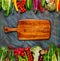 Collection of fresh vegetables with breadboard