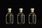 Collection glass bottles for cosmetic, perfume, drink with black label, cork, yellow liquid in a row on dark black background.