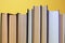 Collection of hardcover books on yellow background, closeup