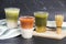 Collection of iced tea drinks thai milk tea matcha latte and yuzu green tea served in plastic glass put on cutting board and cloth