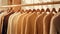 a collection of light brown sweaters neatly arranged on hangers in a well-lit and stylish boutique setting. the classic