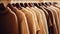a collection of light brown sweaters neatly arranged on hangers in a well-lit and stylish boutique setting. the classic