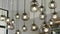 Collection of modern spherical glass pendant lights hanging from ceiling. Bright bulbs emitting warm and inviting glow