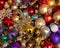 Collection of multicoloured Christmas baubles and tinsel for decorating a Christmas tree. The decorations are cheap and old, and a