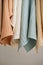 Collection of natural muslin kitchen towels are hung in a row on an unusual wooden hanger. Natural, soft, airy and