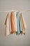 Collection of natural muslin kitchen towels are hung in a row on an unusual wooden hanger. Natural, soft, airy and