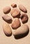 Collection of nine pink toned sea stones on sand