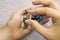 Collection Of Semi-Precious Gemstones colorless quartz in woman hands on blurred grey knitted background