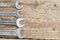 A collection of small wrenches on wooden background.