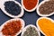 Collection of spices in wooden spoons Saffron, Basil, Turmeric, Caraway seeds, Sweet Paprika, Black Lava Sea Salt on dark