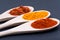 Collection of Spices in wooden spoons Saffron, Turmeric powder, Sweet Paprika on dark
