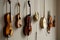 A collection of stringed musical instruments and vintage clocks mounted on a wall as an artistic display
