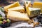 Collection of swiss, holland, french, italian cheeses with nuts and grapes. Dark background. Top view