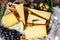 Collection of swiss, holland, french, italian cheeses with nuts and grapes. Dark background. Top view