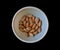 Collection Wet soaked almonds in a plastic bowl isolated on black.