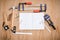 Collection of worktools, set of working tools. (Steel wrench, hammer, nails, bolts, wrenches, etc.) with notebook on the wooden ta