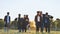 College alumni friends pose in the evening meadow.