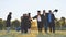 College alumni friends pose in the evening meadow.