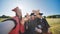 College alumni take selfies in the meadow.