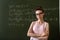 college female student writing on blackboard completing mathematical equations