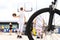 College playground. View of the basketball court through the wheel of the bike. Young people play basketball. View from the back.