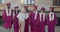 College professor hugging group of young people in graduation hats and mantles congratulating on successful education