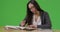 A college student does her homework on green screen