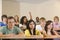 College student with hand raised in lecture