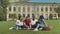 College students studying sitting on green lawn