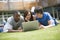 College students using laptop on campus lawn,