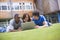 College students using laptop on campus lawn