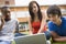 College students using laptop on campus lawn