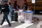 College students were seen at a street fair making sure that the people put their trash in the correct trash receptacles for
