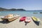 Coloful kayak, sup board and boats on sunny Simos beach in Greece