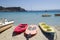 Coloful kayak, sup board and boats on sunny Simos beach in Greece