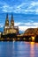 Cologne Cathedral city skyline and Hohenzollern bridge with Rhine river in Germany at twilight portrait format